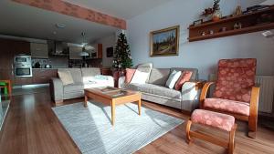 a living room with a couch and a table at Apartmán PONIKLEC v hoteli Residence **** in Donovaly