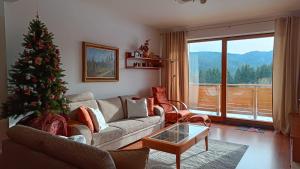 a living room with a christmas tree and a couch at Apartmán PONIKLEC v hoteli Residence **** in Donovaly
