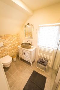 ein Bad mit einem WC, einem Waschbecken und einem Fenster in der Unterkunft Romantik-Suite Nordelsaß B&B in Oberhoffen-lès-Wissembourg