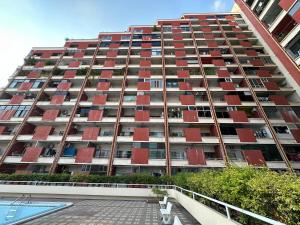 a large apartment building with red balconies on it at Country Complex Bangna in Bangkok