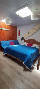 een slaapkamer met een bed en een surfplank aan de muur bij Hostal OlaBrava in Pichilemu