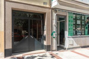 een winkel met glazen deuren en een parkeermeter bij Apartamento Carvajal in Málaga