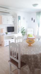een witte woonkamer met een tafel en stoelen bij Apartamento Playa Vera in Vera
