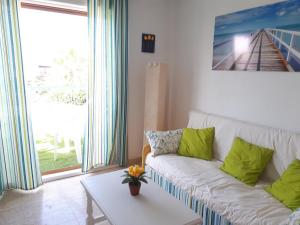 een woonkamer met een witte bank met groene kussens bij Apartamento Playa Vera in Vera