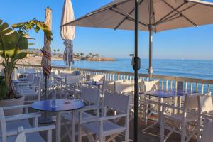 a restaurant with tables and chairs and the ocean at "Le beach", plein centre, climatisé in Menton