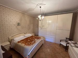 een slaapkamer met een bed en een kroonluchter bij casa belvedere a Valle San Martino di Spoleto in Spoleto