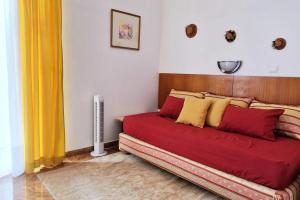 Schlafzimmer mit einem Bett mit roten und gelben Kissen in der Unterkunft Villa Alta Vista in São Jorge