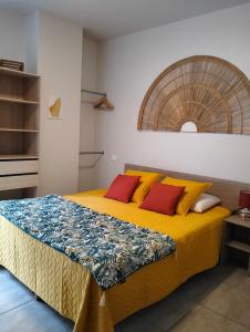 a bedroom with a bed with yellow and red pillows at Tikazéla - Escale Tournon-Sur-Rhône in Tournon-sur-Rhône