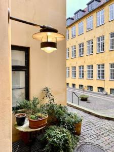 a building with potted plants and a light on it at Cosy Old-Town Appartment in Copenhagen in Copenhagen