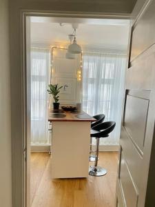 cocina con encimera y 2 taburetes en una habitación en Cosy Old Town Apartment in Copenhagen Gammel Strand, en Copenhague