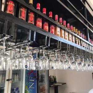 a bunch of wine glasses are lined up on a shelf at Perriman Hotel in Kokrobite