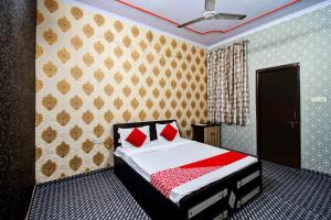 a bedroom with a bed with red pillows on it at OYO Hotel Rao Residency in Jaipur