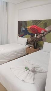 1 dormitorio con 2 camas y un cuadro en la pared en Apto Eco Resort Capivari - CTBA, en Campina Grande do Sul
