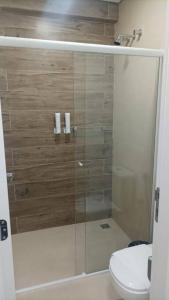 La salle de bains est pourvue d'une douche en verre et de toilettes. dans l'établissement Apto Eco Resort Capivari - CTBA, à Campina Grande do Sul