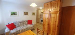 un salon avec un canapé et une cuisine dans l'établissement Appartamento Pampeago 10, à Tesero