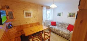 un salon avec un canapé et une table dans l'établissement Appartamento Pampeago 10, à Tesero