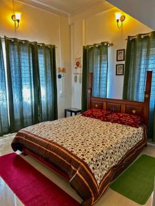 a bedroom with a large bed with green curtains at Cornwall for family in Madikeri