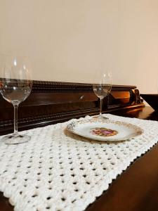 uma mesa com um prato e dois copos de vinho em Casinha aconchegante em meio a natureza em Rio Acima