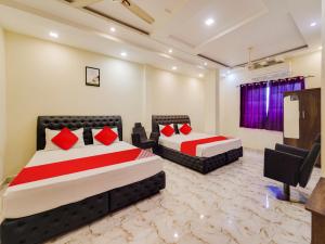 two beds in a room with red pillows at Moonlight Stays in Chennai