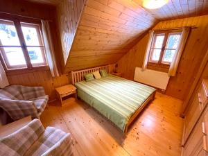 ein Schlafzimmer mit einem Bett in einem Holzzimmer in der Unterkunft Chalupa pod lipou in Zázrivá