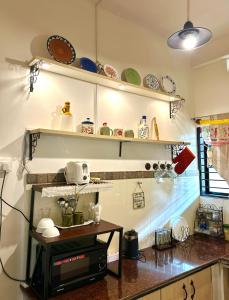 a kitchen with plates and dishes on the shelves at Cornwall for family in Madikeri
