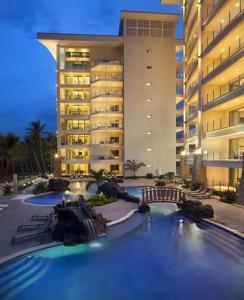 una piscina con un tobogán de agua frente a un edificio en Elegant Beachfront Condo at Diamonte del Sol - 801s, en Jacó