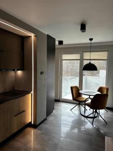a kitchen and dining room with a table and chairs at HELLO Apartamenty - Pinia blisko Aquaparku in Karpacz