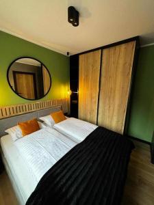 a bedroom with a large bed with a mirror at HELLO Apartamenty - Pinia blisko Aquaparku in Karpacz