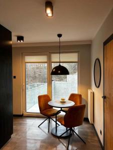 a dining room with a table and chairs and a window at HELLO Apartamenty - Pinia blisko Aquaparku in Karpacz