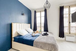 Schlafzimmer mit blauen Wänden und einem Bett mit einem Tisch in der Unterkunft Guest loc-Le Saphir-3min château in Versailles + 15 Fotos