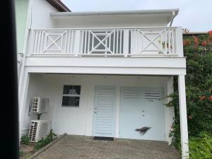 a white garage with a balcony on top of it at Luxury Waterfront Villa 249C South Beach in Jolly Harbour
