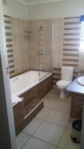 łazienka z wanną, toaletą i prysznicem w obiekcie Mzanzi Rock Guesthouse w mieście Johannesburg