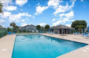 a large swimming pool with blue chairs around it at Little River-condo-sleeps 10 By Hostique in Little River