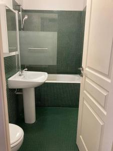 uma casa de banho com um lavatório, um WC e uma banheira em Appart. 100m², 4 pièces, 2 salle de bains, calme. em Paris