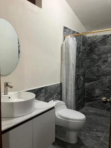 a bathroom with a toilet and a sink and a shower at Haven´s Inn in Baños