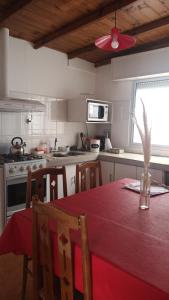 une cuisine avec une table et un chiffon rouge dans l'établissement Casa Privada 2 habitaciones, amueblada Centro Necochea, à Necochea