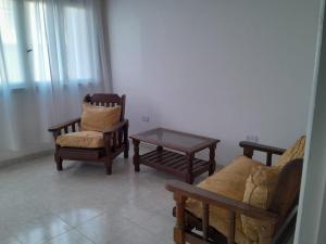 - un salon avec trois chaises et une table basse dans l'établissement Casa Privada 2 habitaciones, amueblada Centro Necochea, à Necochea