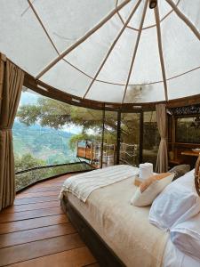 1 dormitorio con cama y vistas a la montaña en Paneo Glamping, en Floridablanca