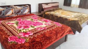 two beds sitting next to each other in a room at Shri Badrivishal -A mata Hotel in Badrīnāth