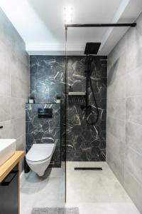 a bathroom with a shower with a toilet and a sink at Downtown Elegance in Budapest