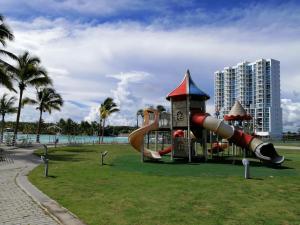 a playground in a park with a slide at Playa Blanca Town Center Suites in Río Hato