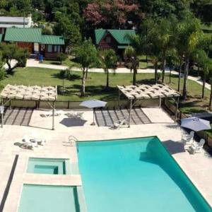 eine Aussicht auf einen Pool in einem Resort in der Unterkunft Cabañas El Mangrullo de Obligado in Vuelta de Obligado