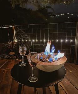 a fire pit on a table with two glasses of wine at Paneo Glamping in Floridablanca +19 photos
