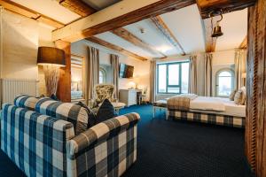 ein Hotelzimmer mit 2 Betten und einem Sofa in der Unterkunft Hotel Alter Kornspeicher in Neustrelitz