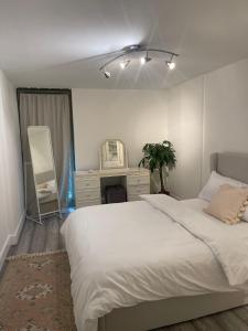 1 dormitorio con cama blanca y espejo en CENTRAL London Luxury APP, en Londres
