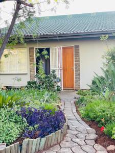 a house with a walkway leading to the front door at The M-Pire Cottage in Bloemfontein