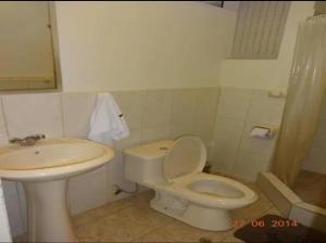 a bathroom with a toilet and a sink at Hostal El Puerto in Yurimaguas