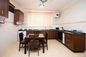 a kitchen with a table and chairs in it at Stay Play Away Residences - 3 bed, Airport Residential, Accra in Accra