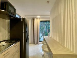 a kitchen with a refrigerator and a counter top at Lalinde by Wynwood House in Medellín
