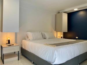 una camera con un grande letto con una parete blu di Lalinde by Wynwood House a Medellín